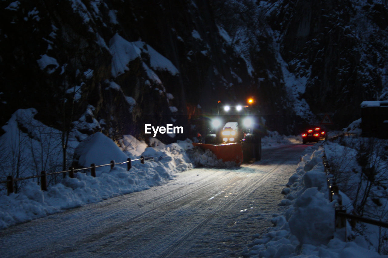 SNOW COVERED STREET AT NIGHT DURING WINTER