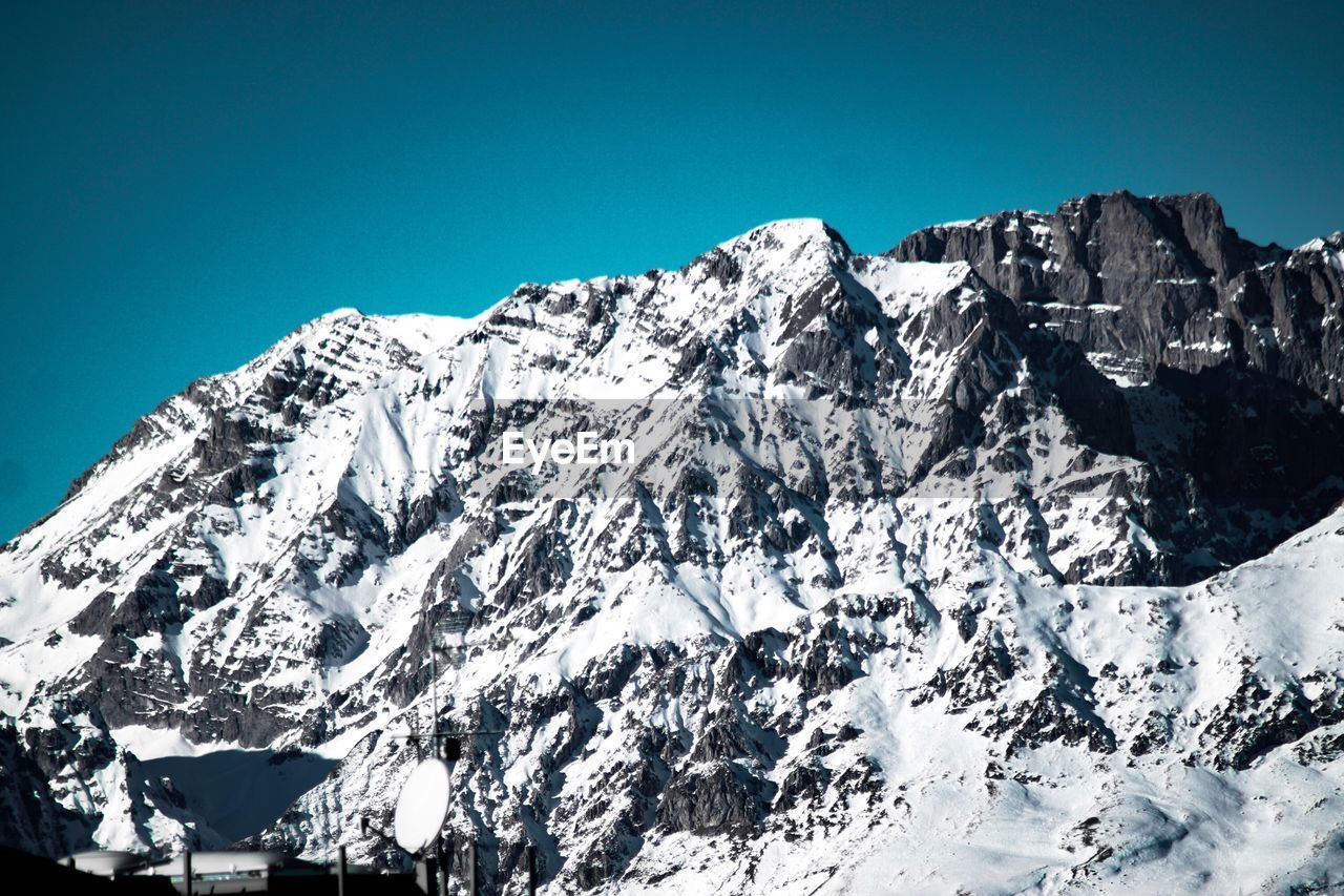 Snowcapped mountains against clear blue sky