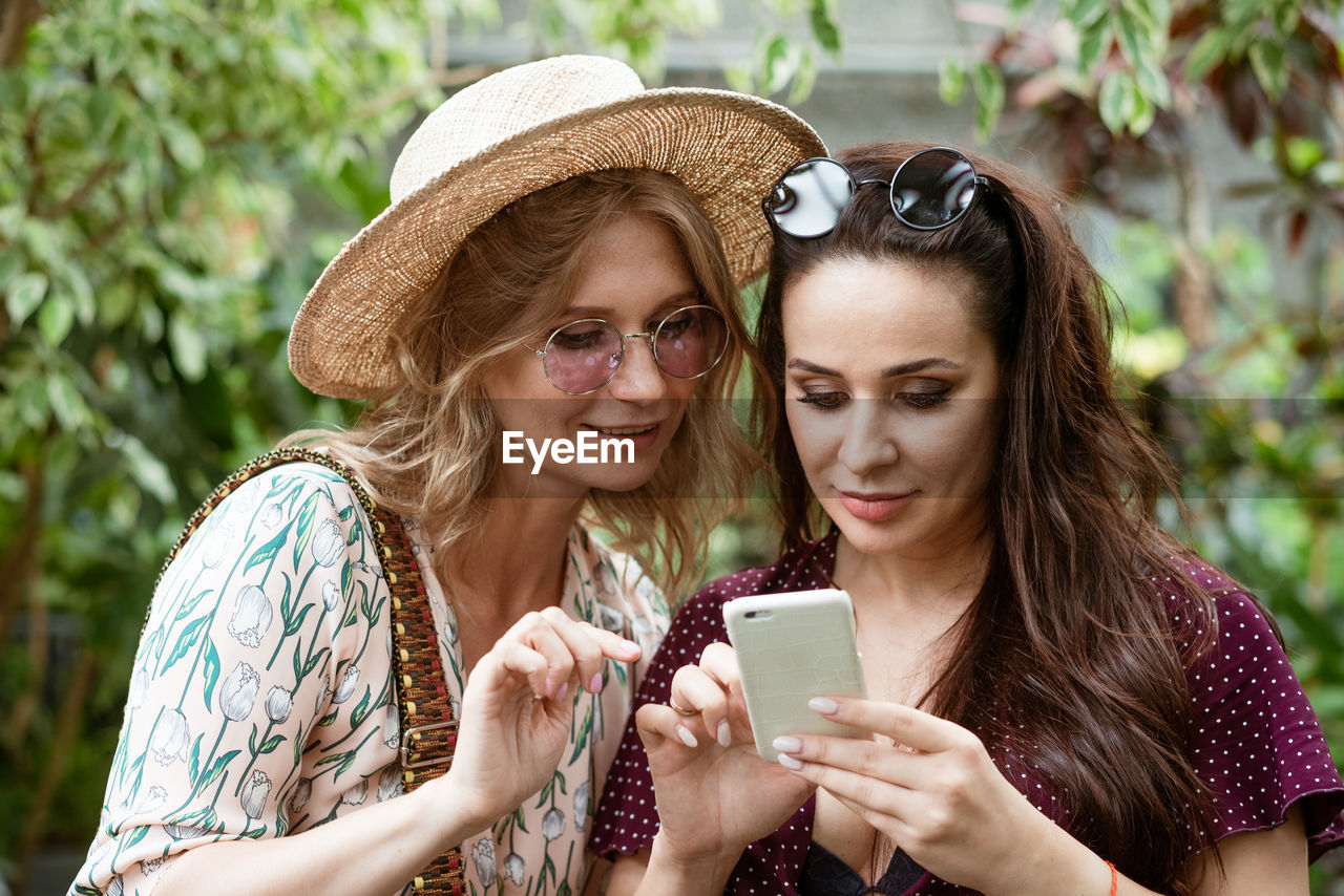 Two girlfriends in the park looking at the phone