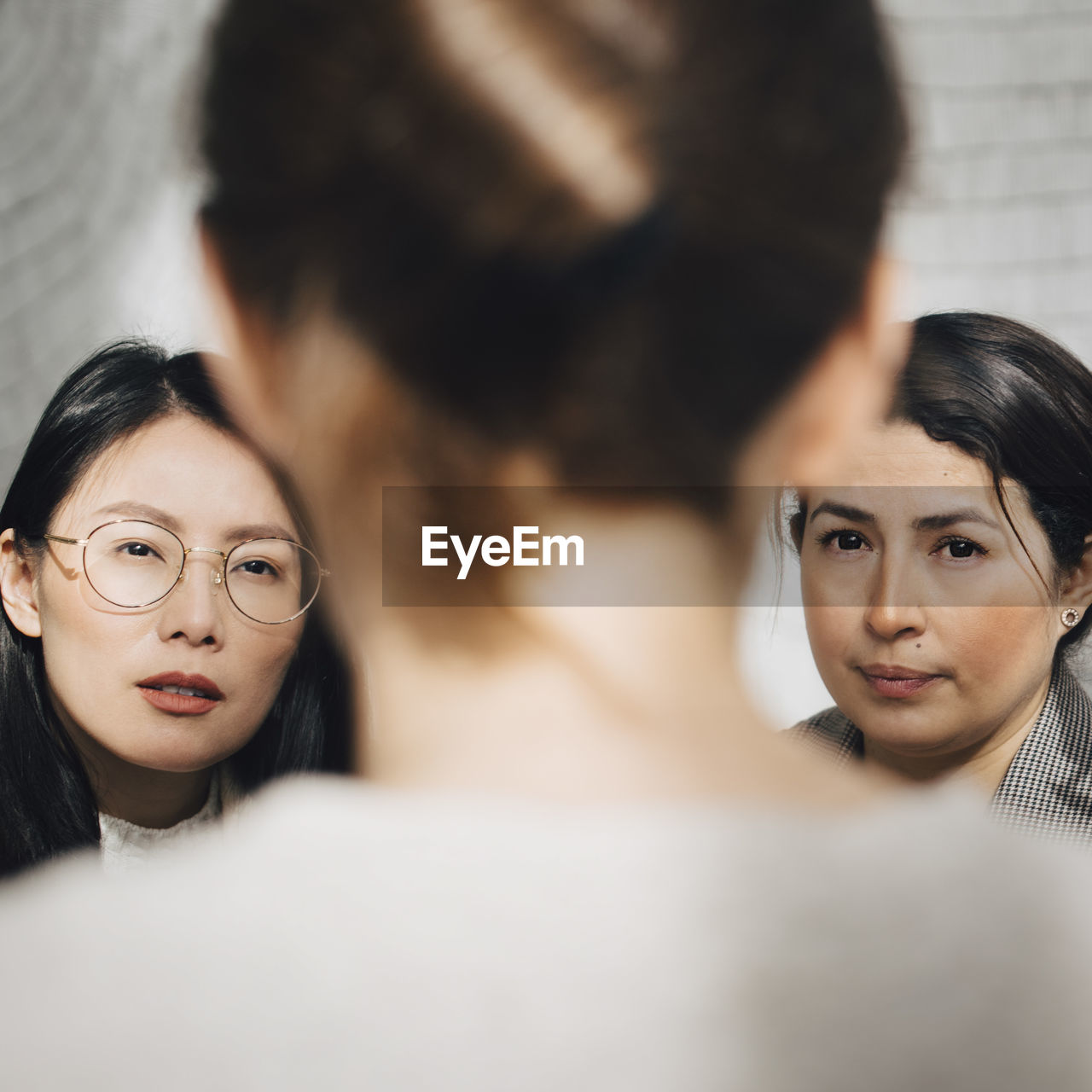 Female colleagues listening to businesswoman in meeting at office