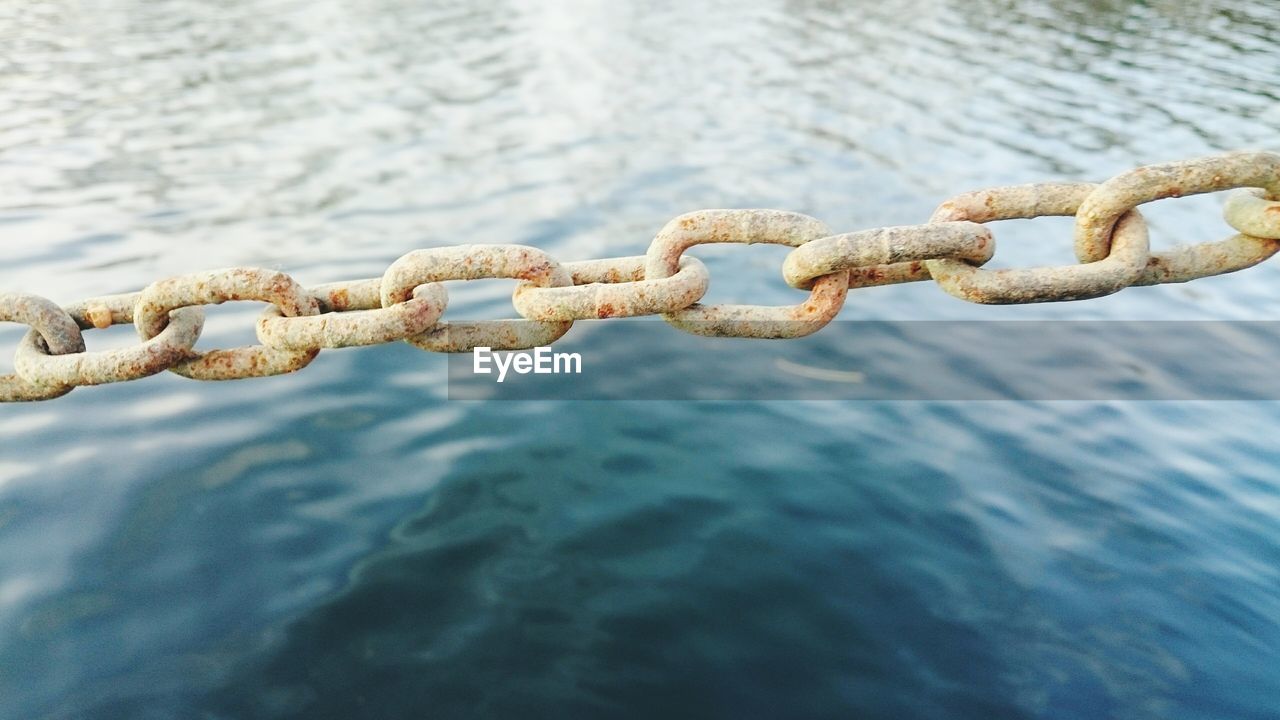 View of sea seen through chainlink fence