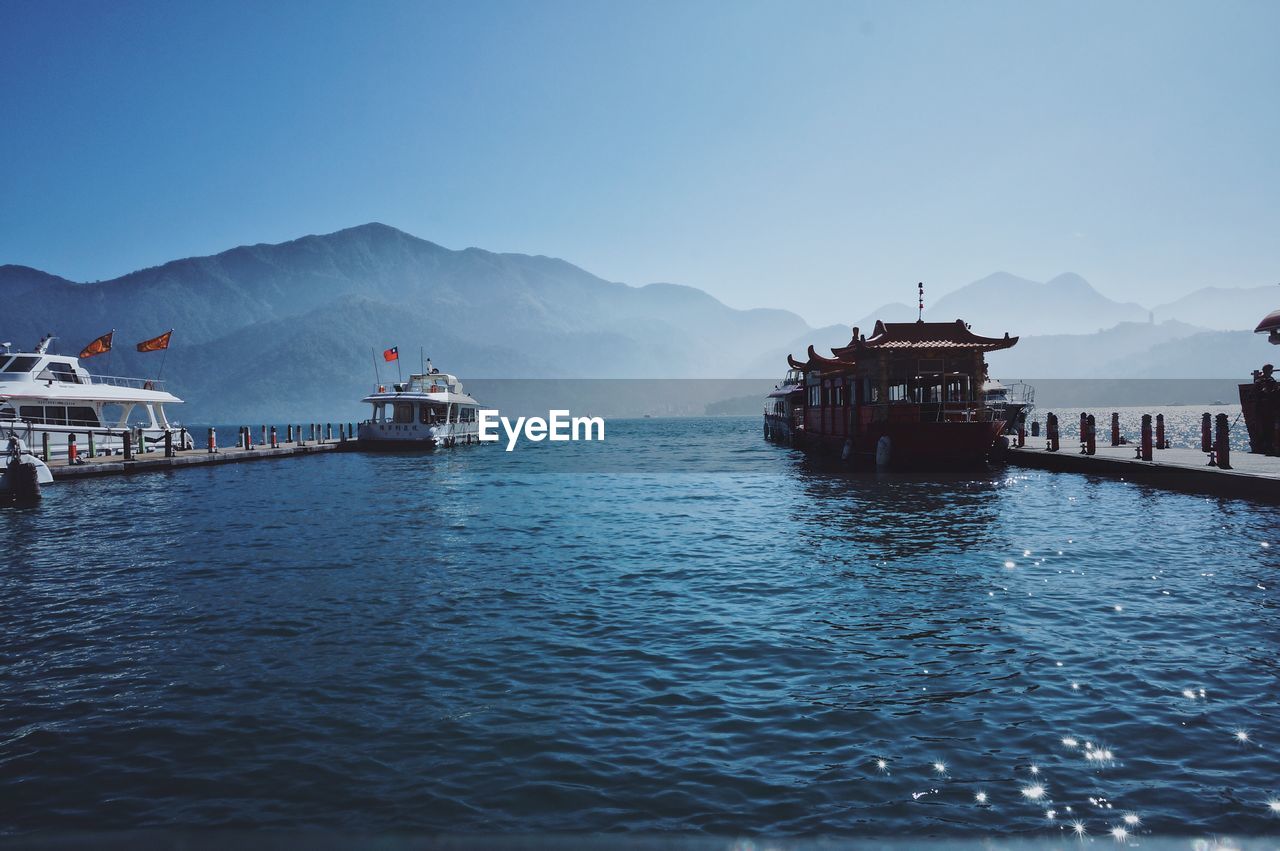 SCENIC VIEW OF SEA AND MOUNTAINS AGAINST CLEAR SKY