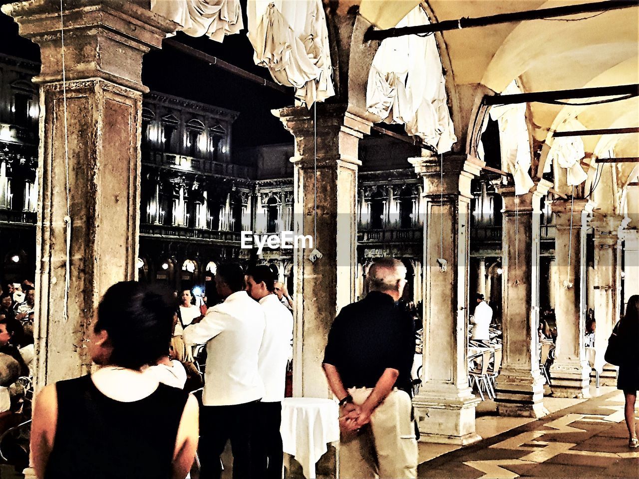 REAR VIEW OF PEOPLE STANDING IN TEMPLE