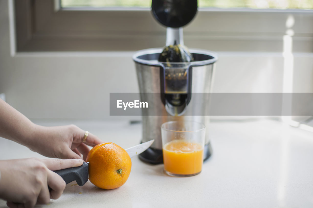 Midsection of man preparing juice in glass on table