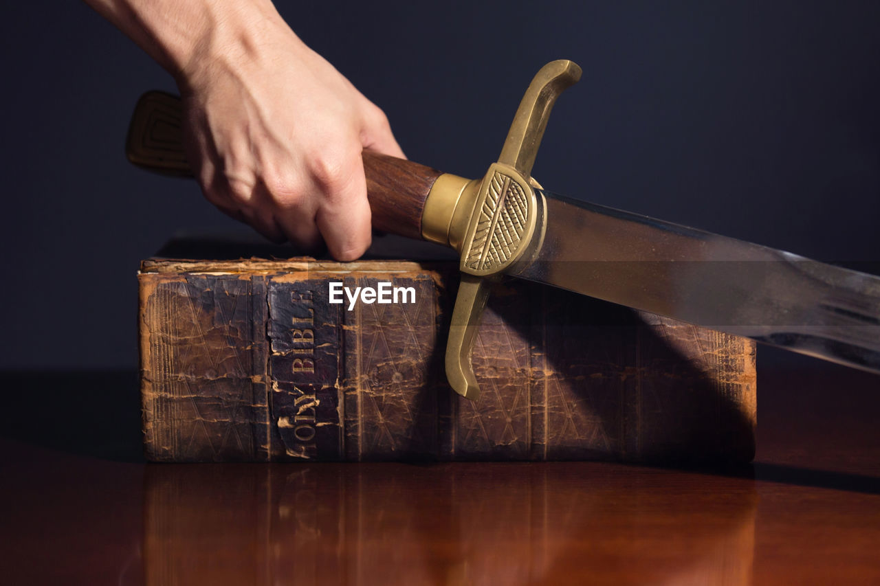 CLOSE-UP OF MAN HOLDING BOOK