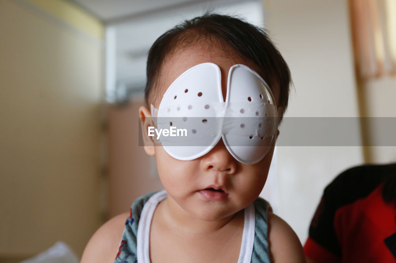 Close-up of cute boy with bandage on eyes at home