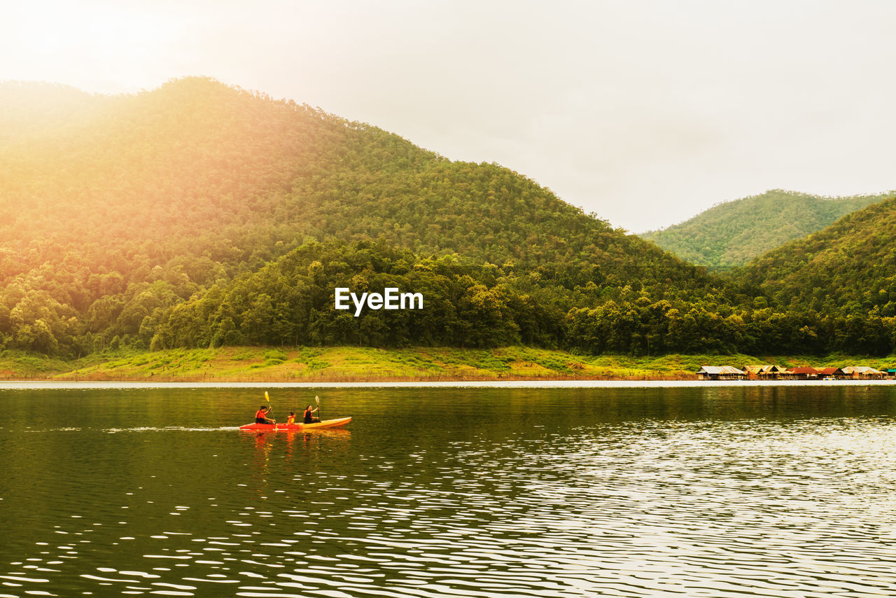 SCENIC VIEW OF PERSON ON LAKE AGAINST SKY