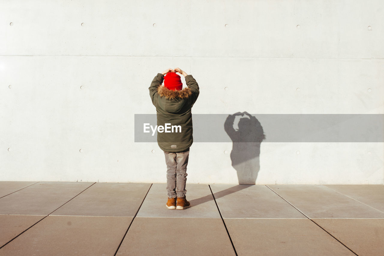 Rear view of boy with shadow on wall