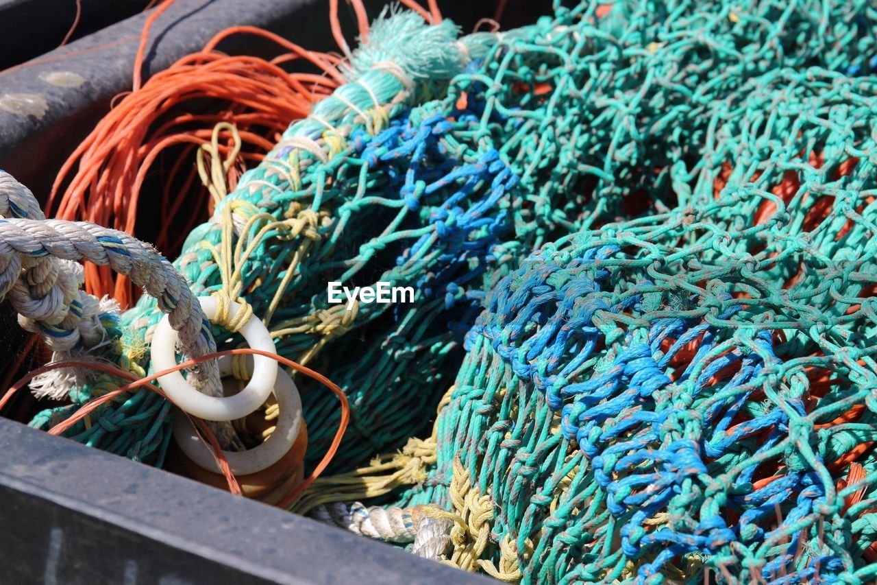 Close-up of fishing nets at harbor during sunny day