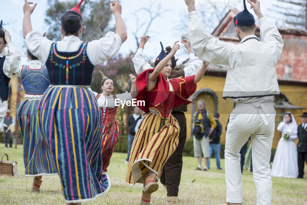 REAR VIEW OF PEOPLE IN TRADITIONAL FESTIVAL