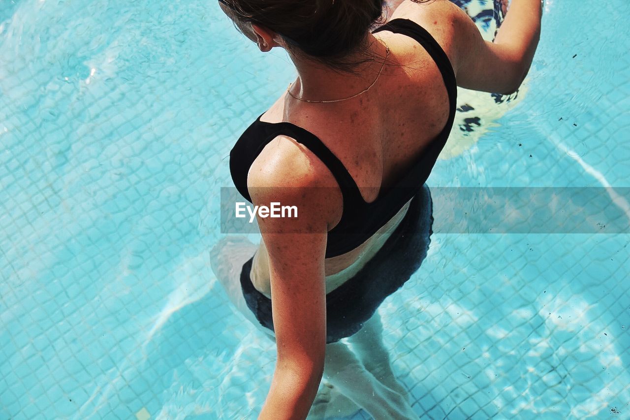 HIGH ANGLE VIEW OF WOMAN STANDING ON POOL TABLE