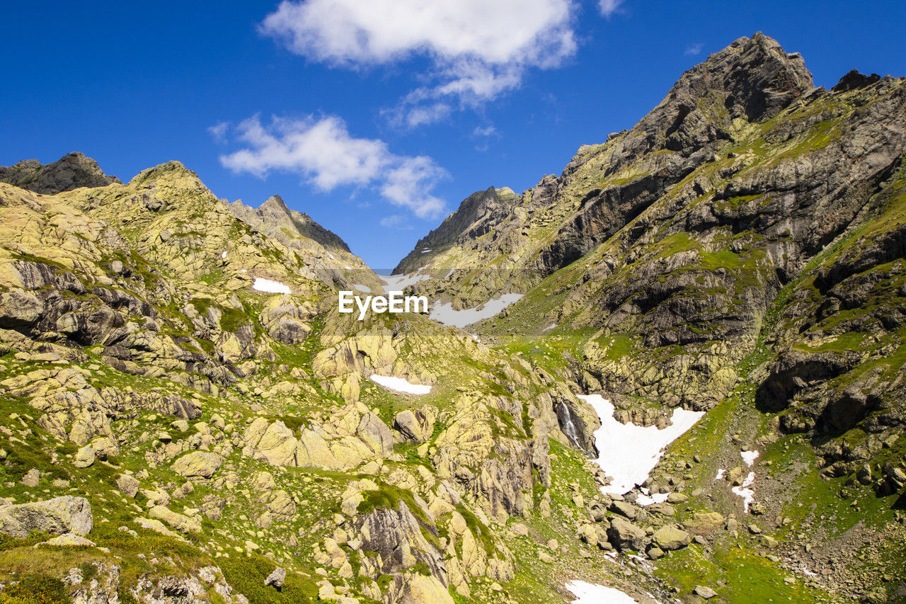 mountain, sky, scenics - nature, environment, beauty in nature, landscape, mountain range, nature, cloud, adventure, rock, travel, land, travel destinations, walking, plant, wilderness, no people, blue, tranquility, non-urban scene, pinaceae, coniferous tree, activity, pine tree, ridge, mountain pass, backpacking, tree, outdoors, tranquil scene, leisure activity, tourism, valley, day, mountain peak, summer, outdoor pursuit, sunlight, pine woodland, plateau, idyllic, sunny, water, forest, green, grass, clear sky