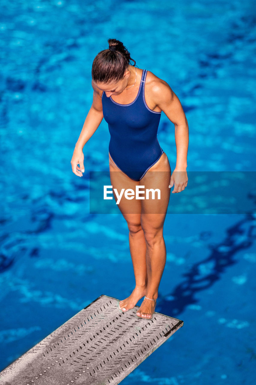 Mid adult woman standing on diving platform