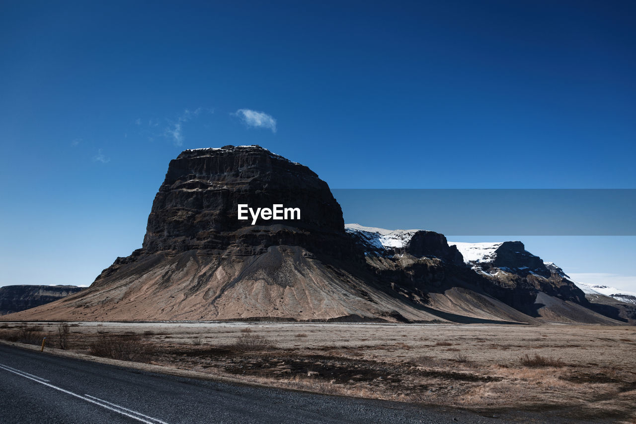 SCENIC VIEW OF ROCK FORMATION AGAINST BLUE SKY