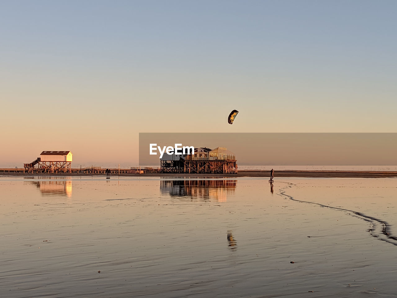 Woman kiteboarding at beach against clear sky