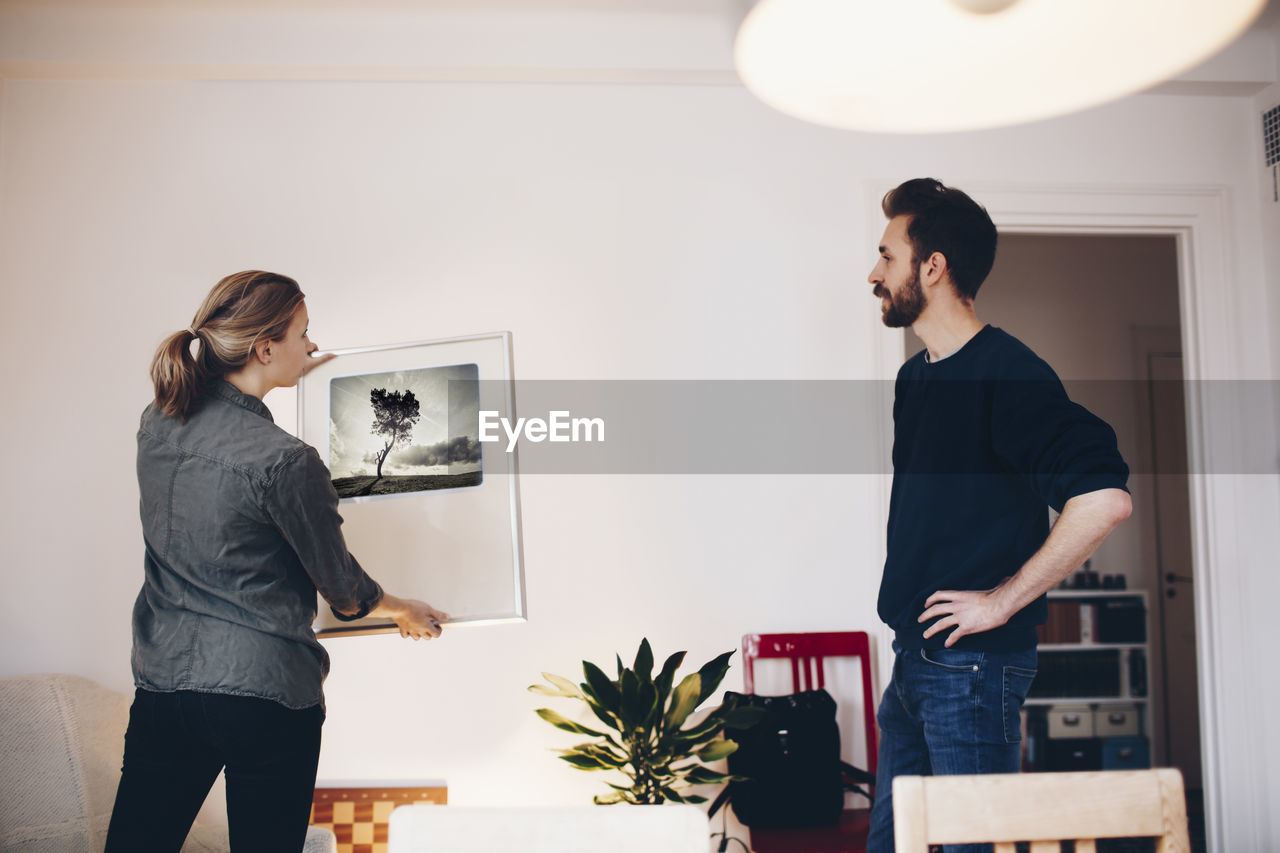 Man and woman discussing painting at home