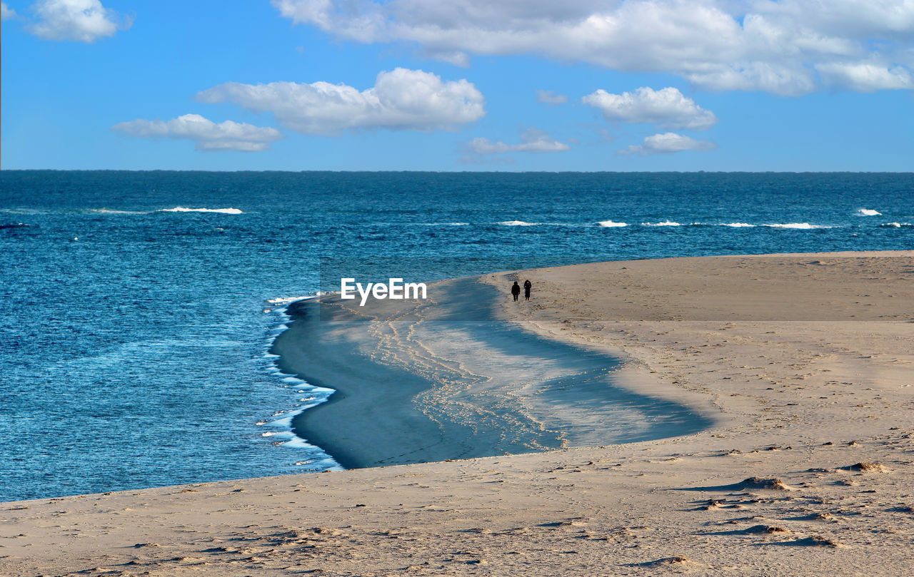 scenic view of beach against cloudy sky