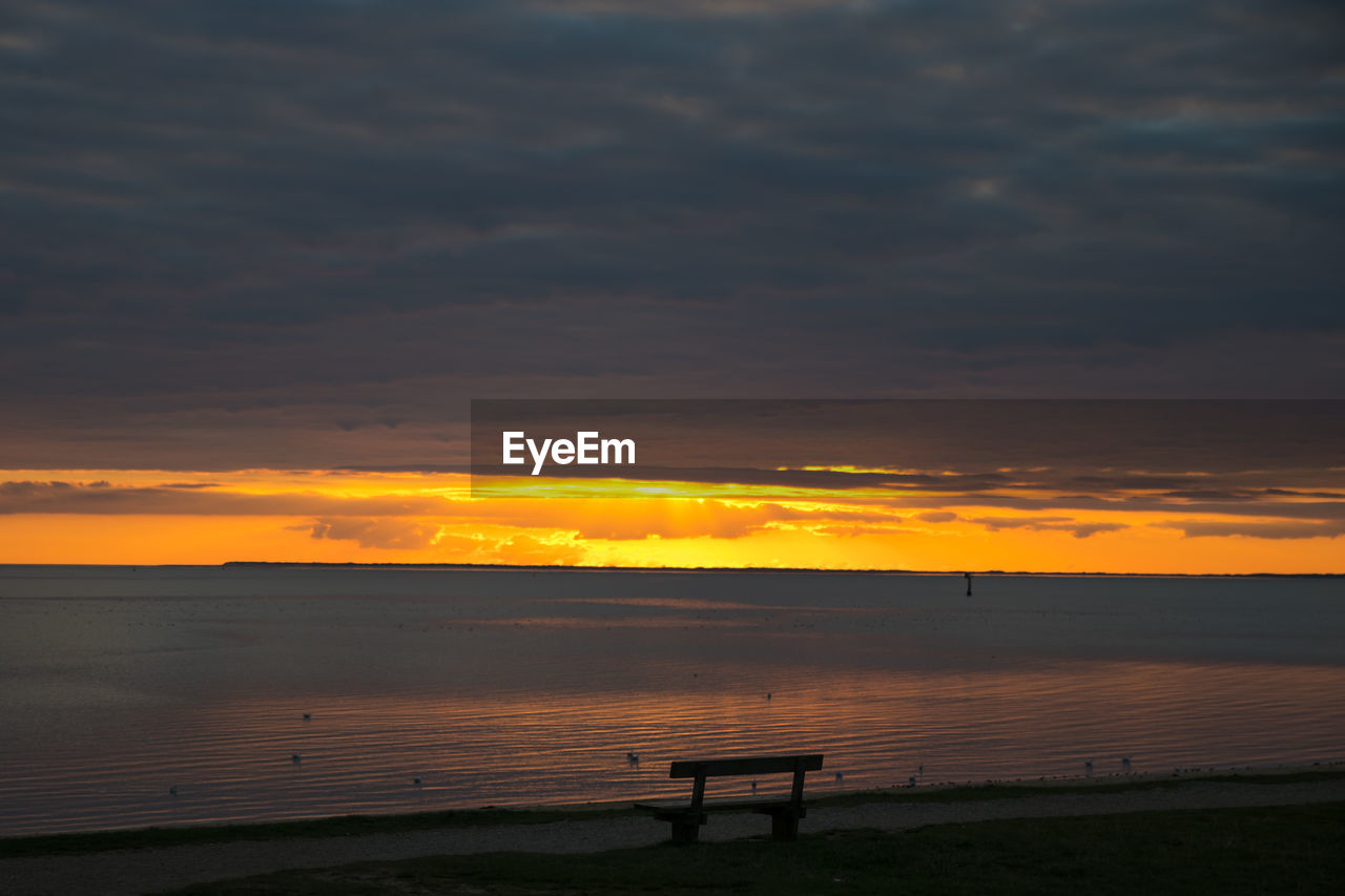 SCENIC VIEW OF CALM BEACH AT SUNSET