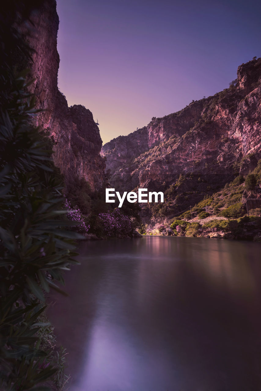 Scenic view of river and mountains against clear sky