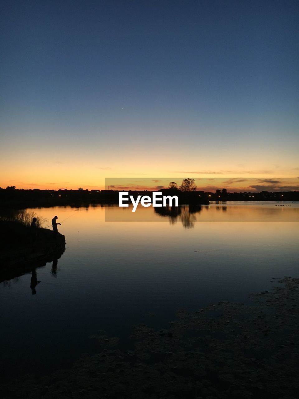 Scenic view of lake against clear sky during sunset
