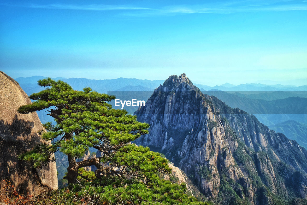Scenic view of mountains against blue sky