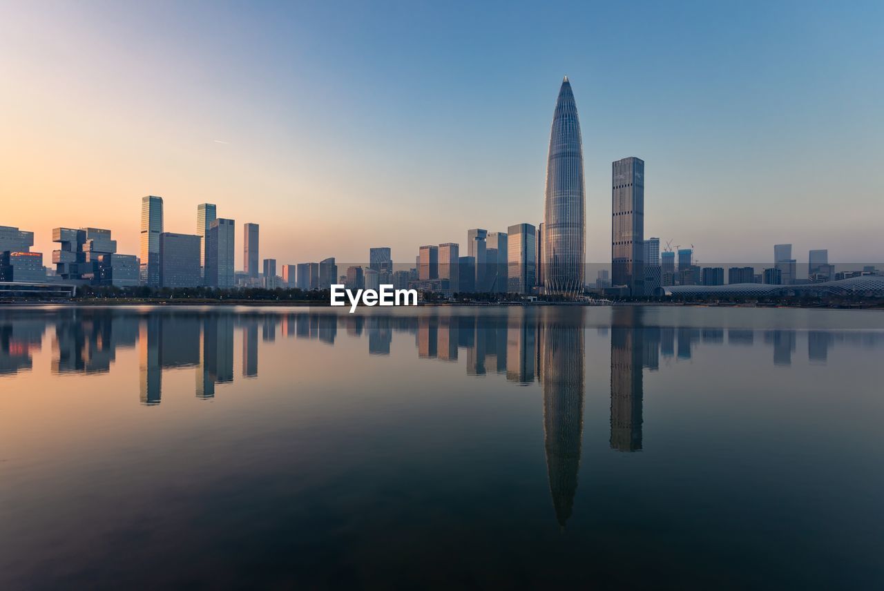 REFLECTION OF BUILDINGS IN CITY AGAINST SKY