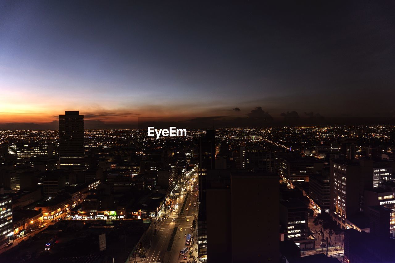 Illuminated cityscape against sky at night