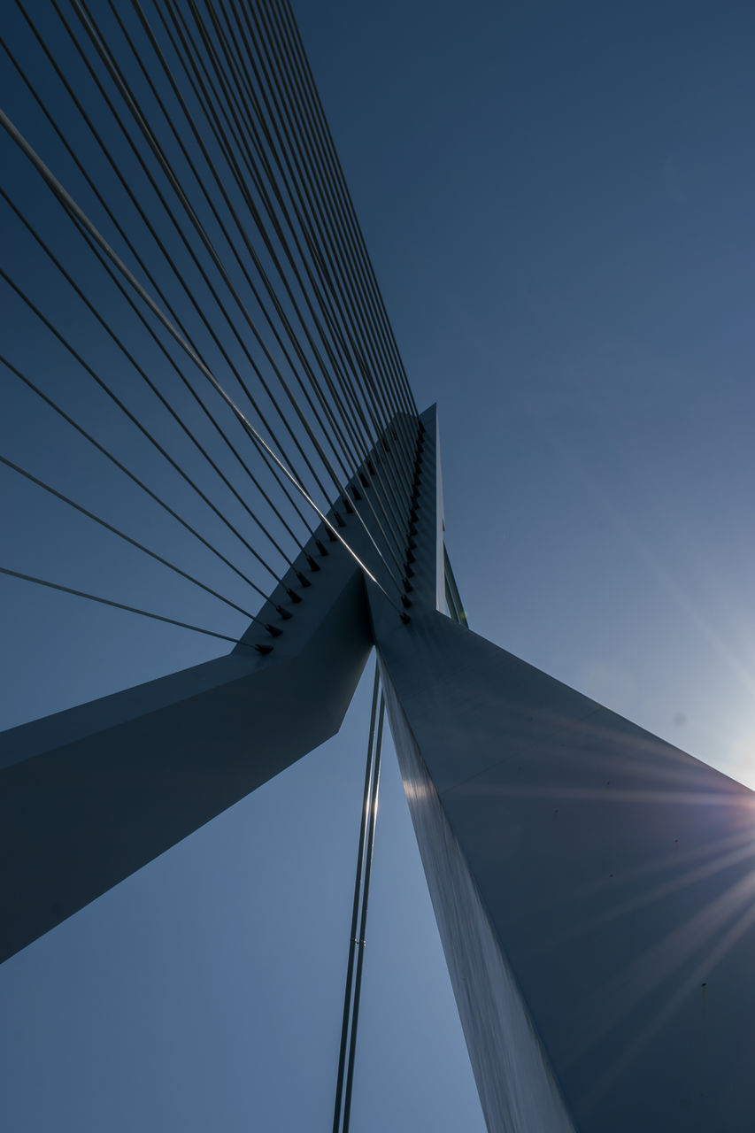 Low angle view of suspension bridge against clear blue sky