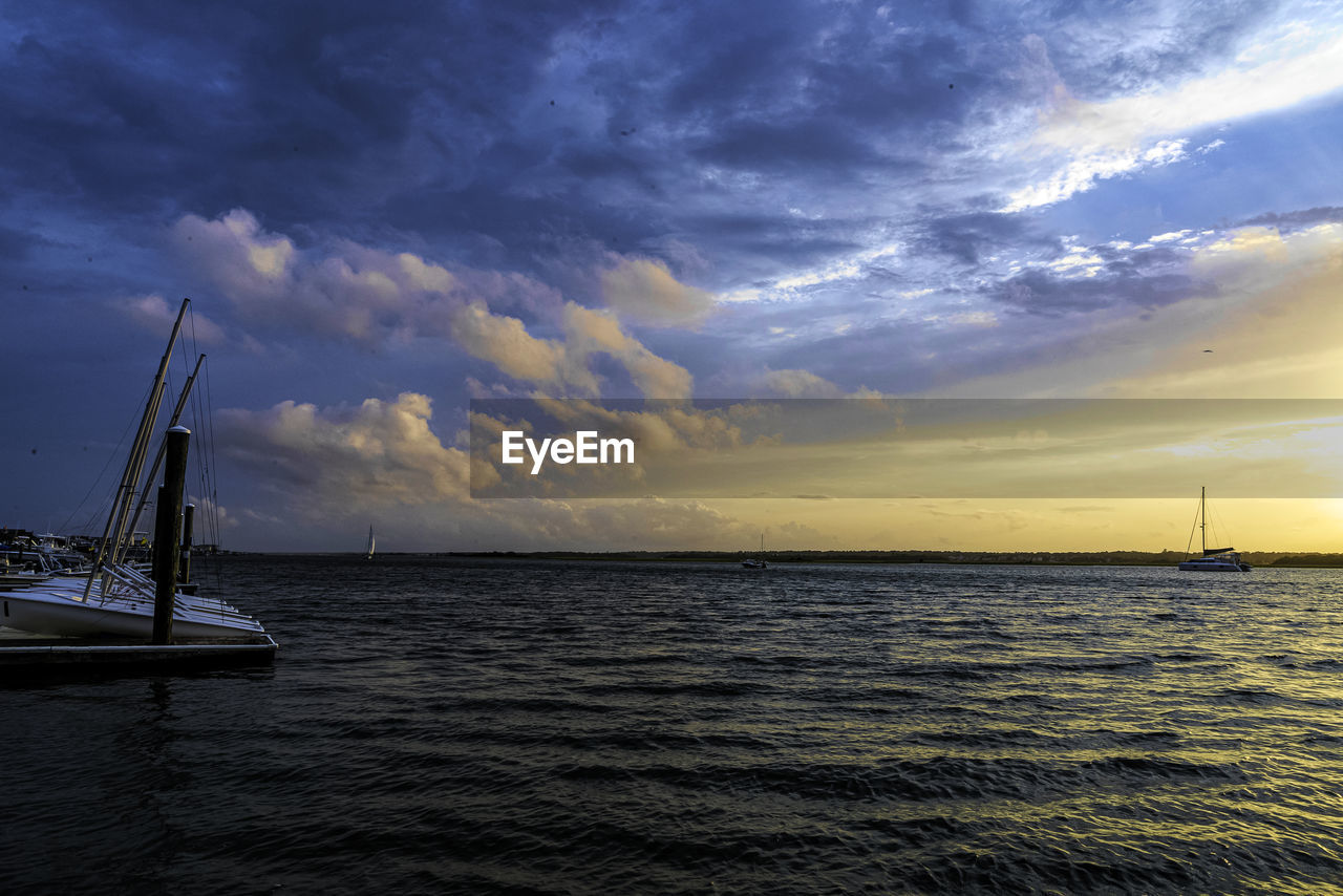 SAILBOAT IN SEA AGAINST SKY DURING SUNSET