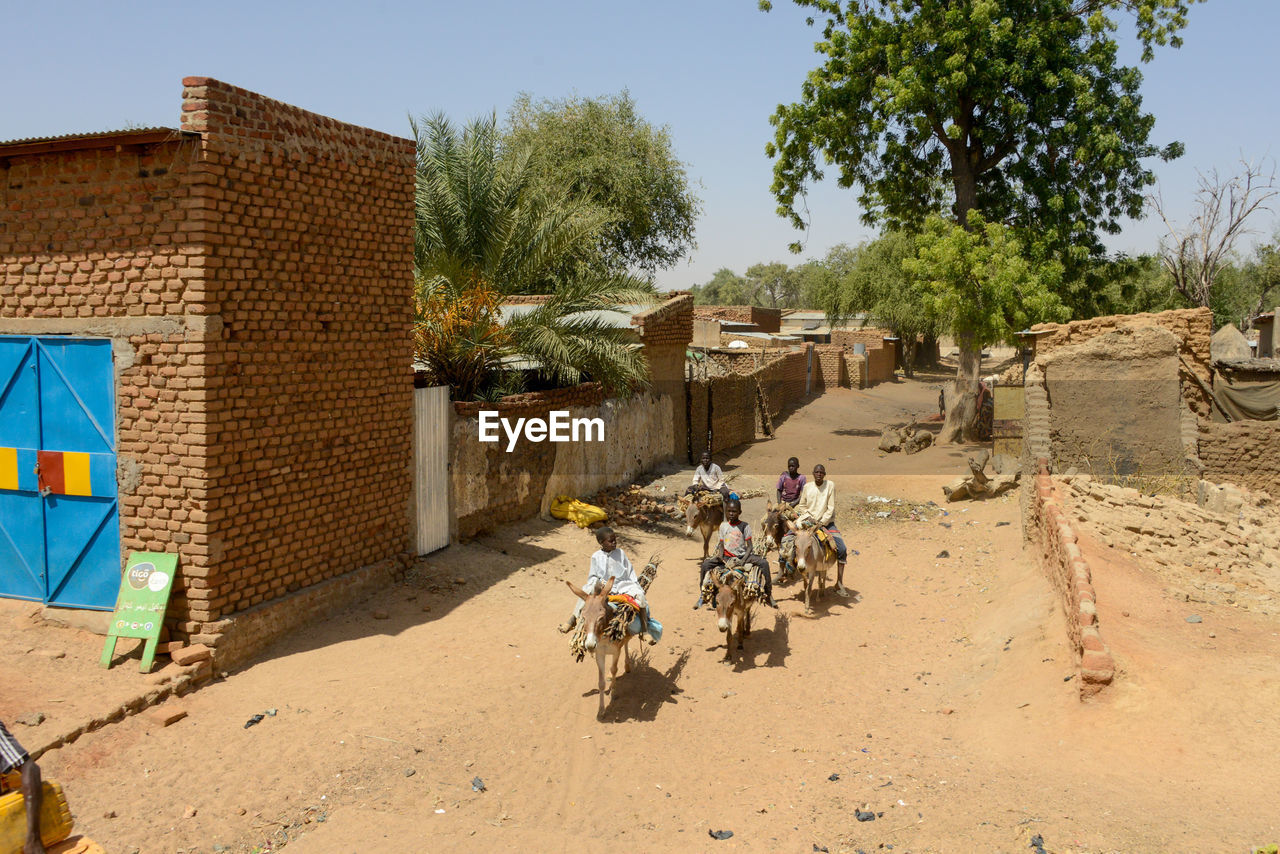 GROUP OF PEOPLE RIDING BICYCLE BY BUILDING