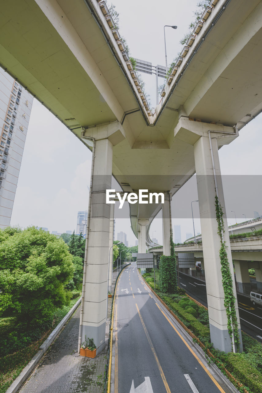 Bridge over highway in city against sky