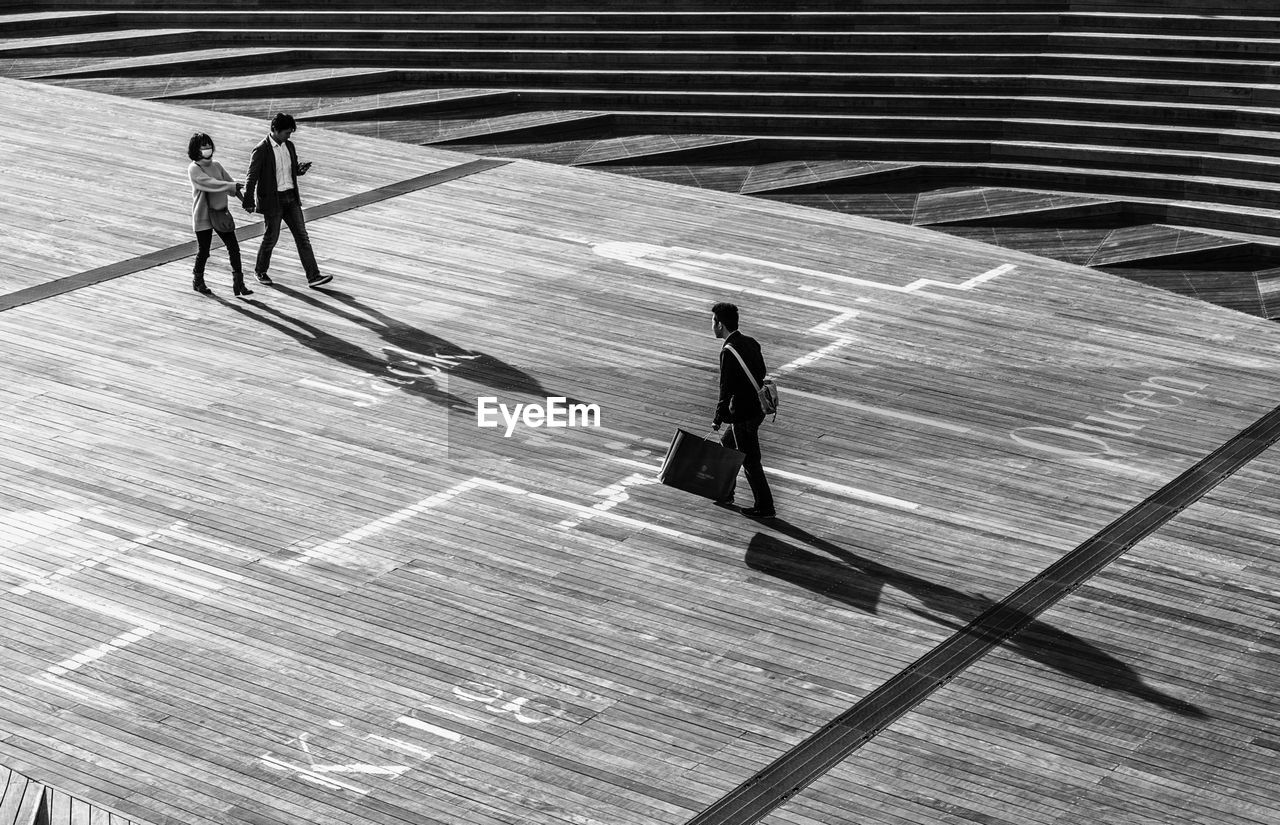 High angle view of people walking on walkway on sunny day