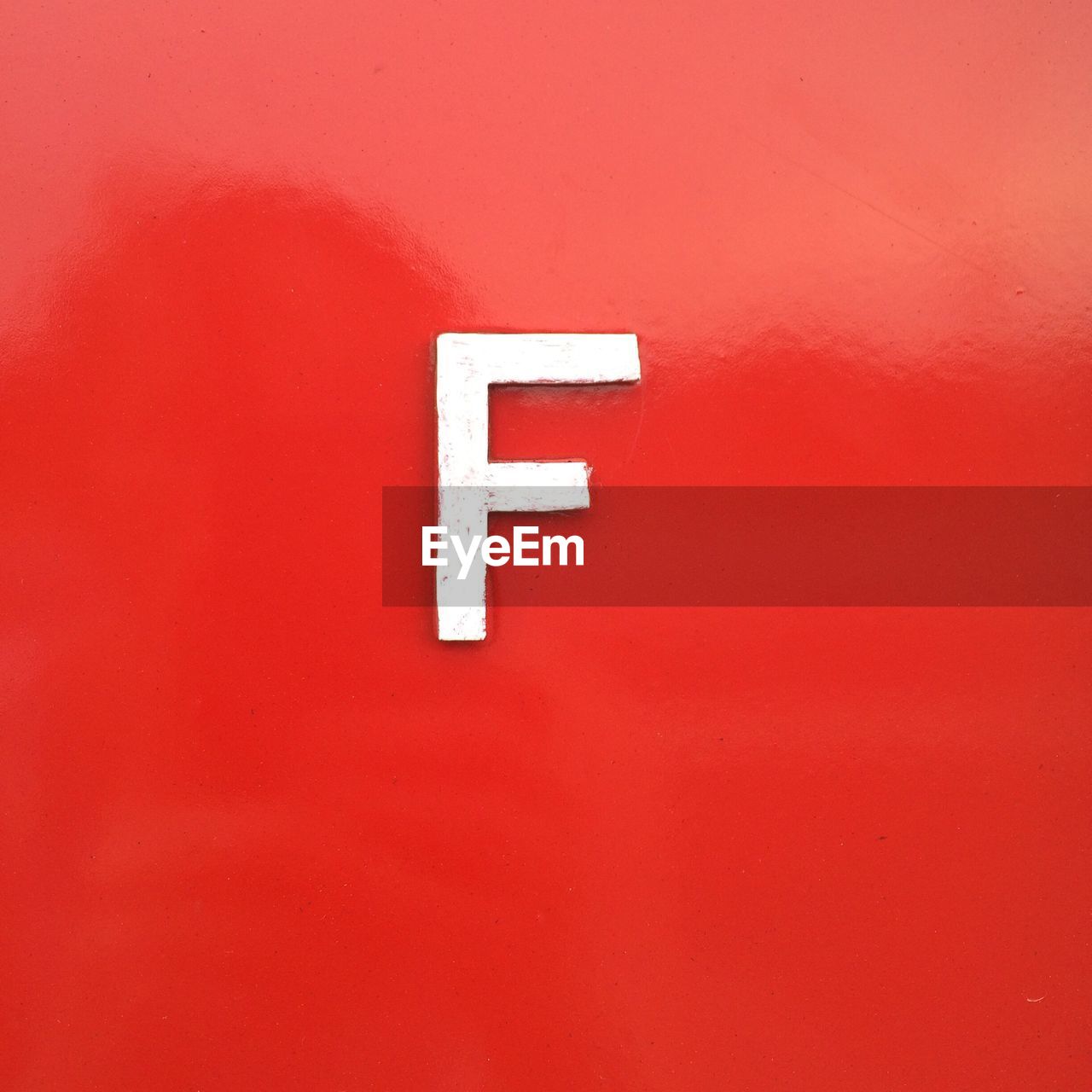 Close-up of letter f on red wall