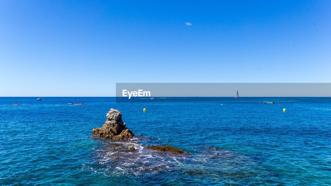 Scenic view of sea against clear blue sky