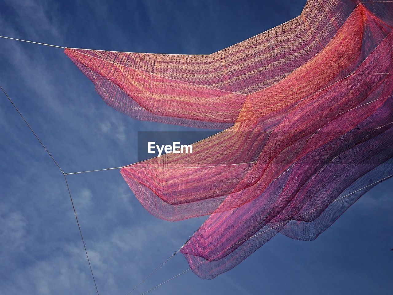 LOW ANGLE VIEW OF MULTI COLORED UMBRELLAS AGAINST SKY