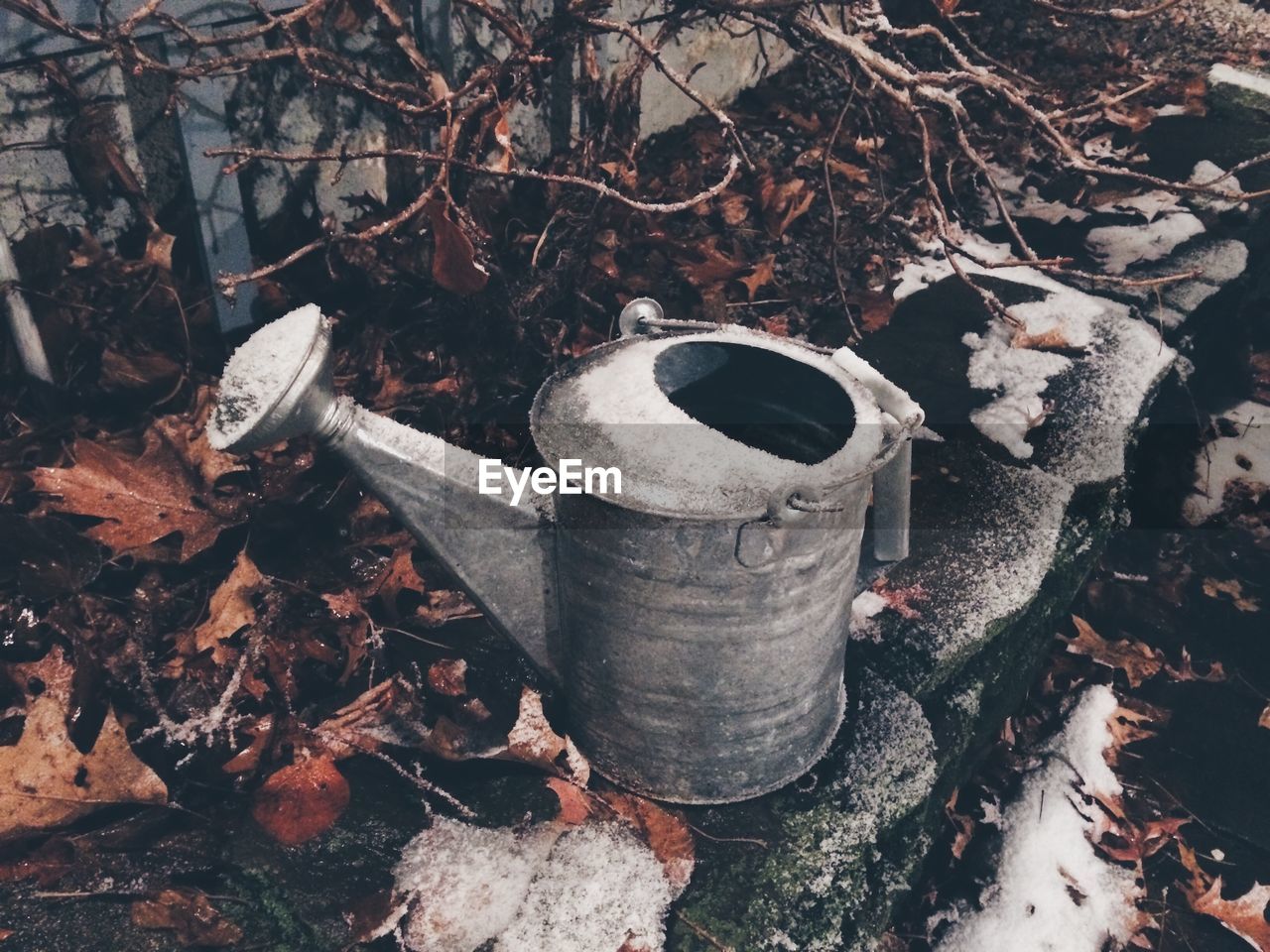 High angle view of snow covered watering can on retaining wall