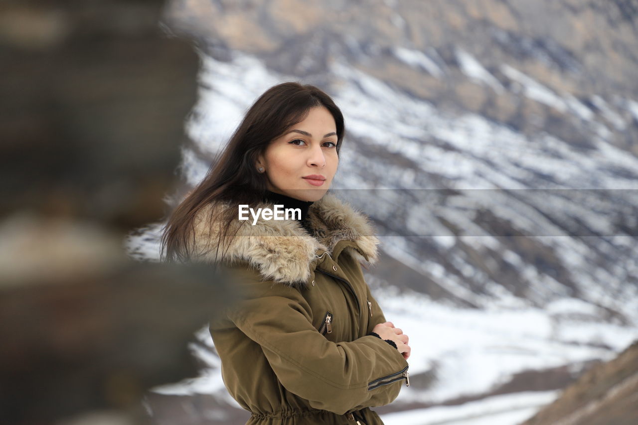 PORTRAIT OF BEAUTIFUL WOMAN STANDING ON SNOW