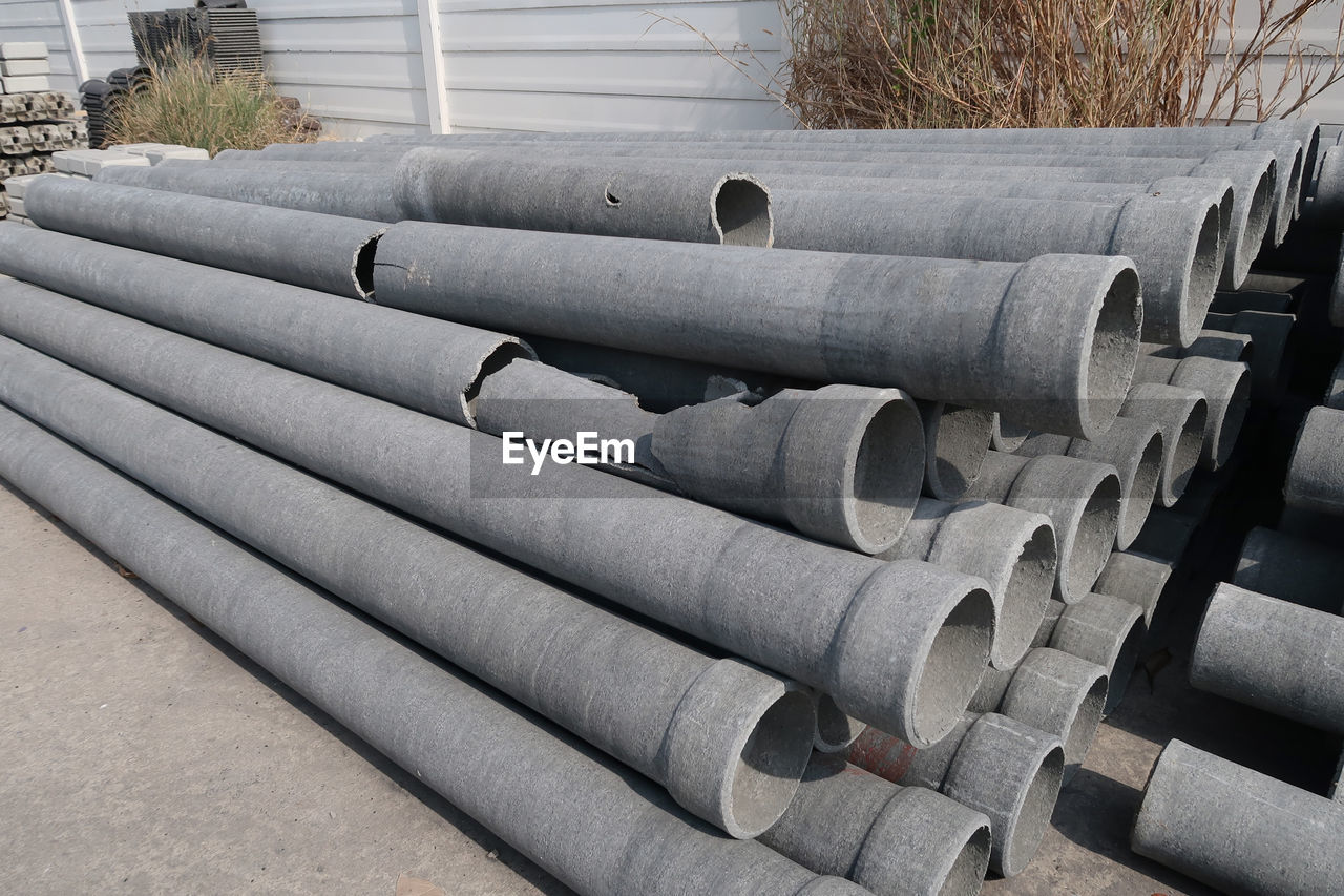 CLOSE-UP OF STACK OF PIPES AGAINST WALL