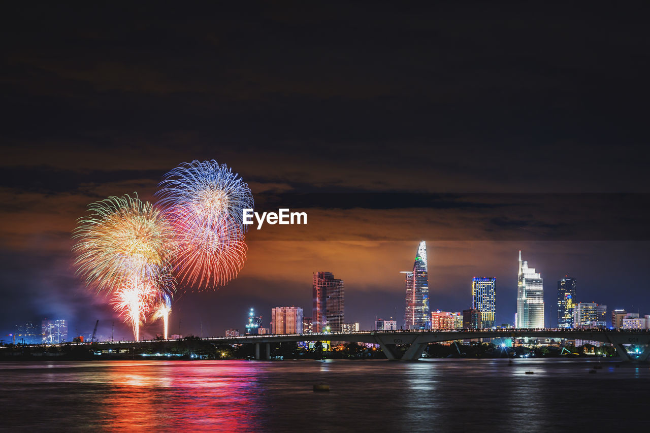 Firework display over illuminated buildings in city at night