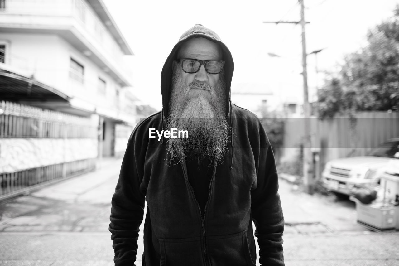 Portrait of man standing on street in city