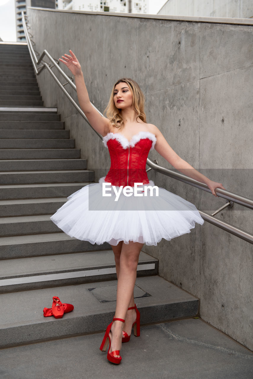 Ballerina wearing high heels and christmas dress performing outdoors
