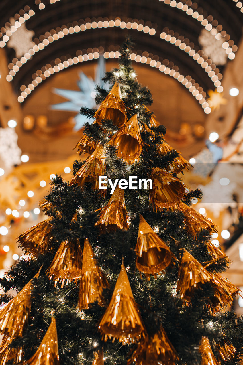 Golden christmas tree decorated with interesting decorations. magic details, festive background