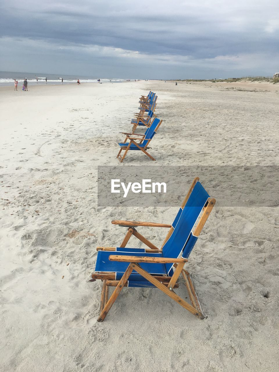 DECK CHAIRS ON SAND AT BEACH