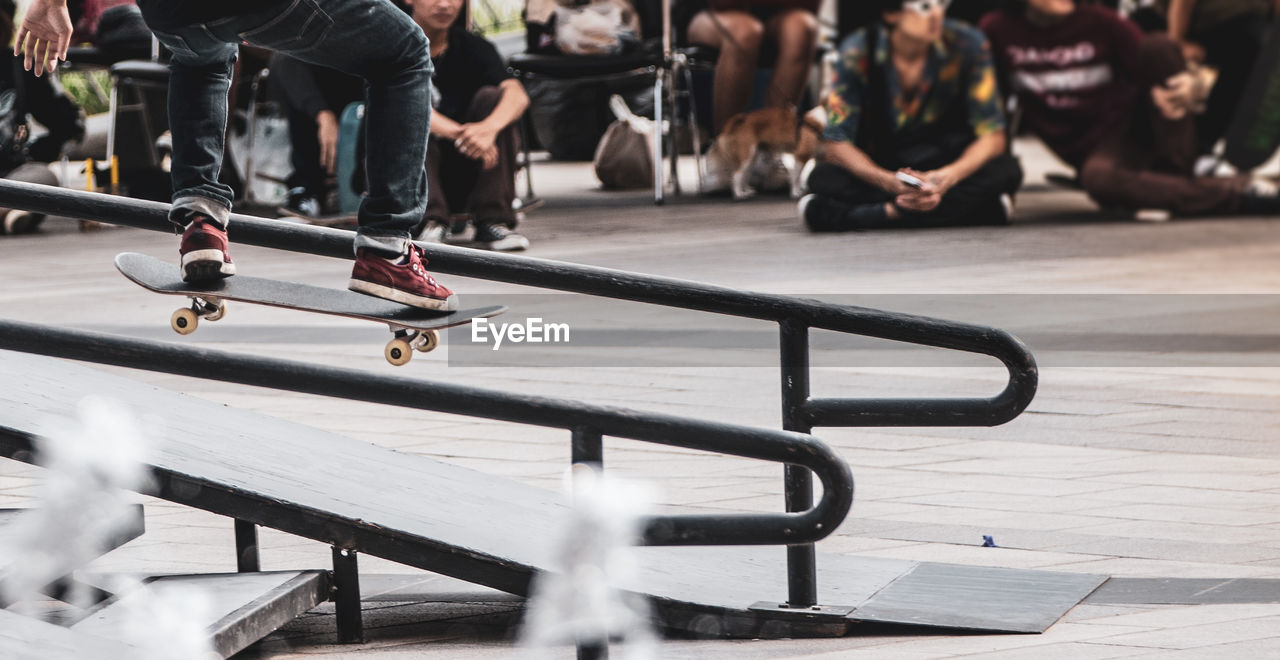 Low section of man skateboarding on railing