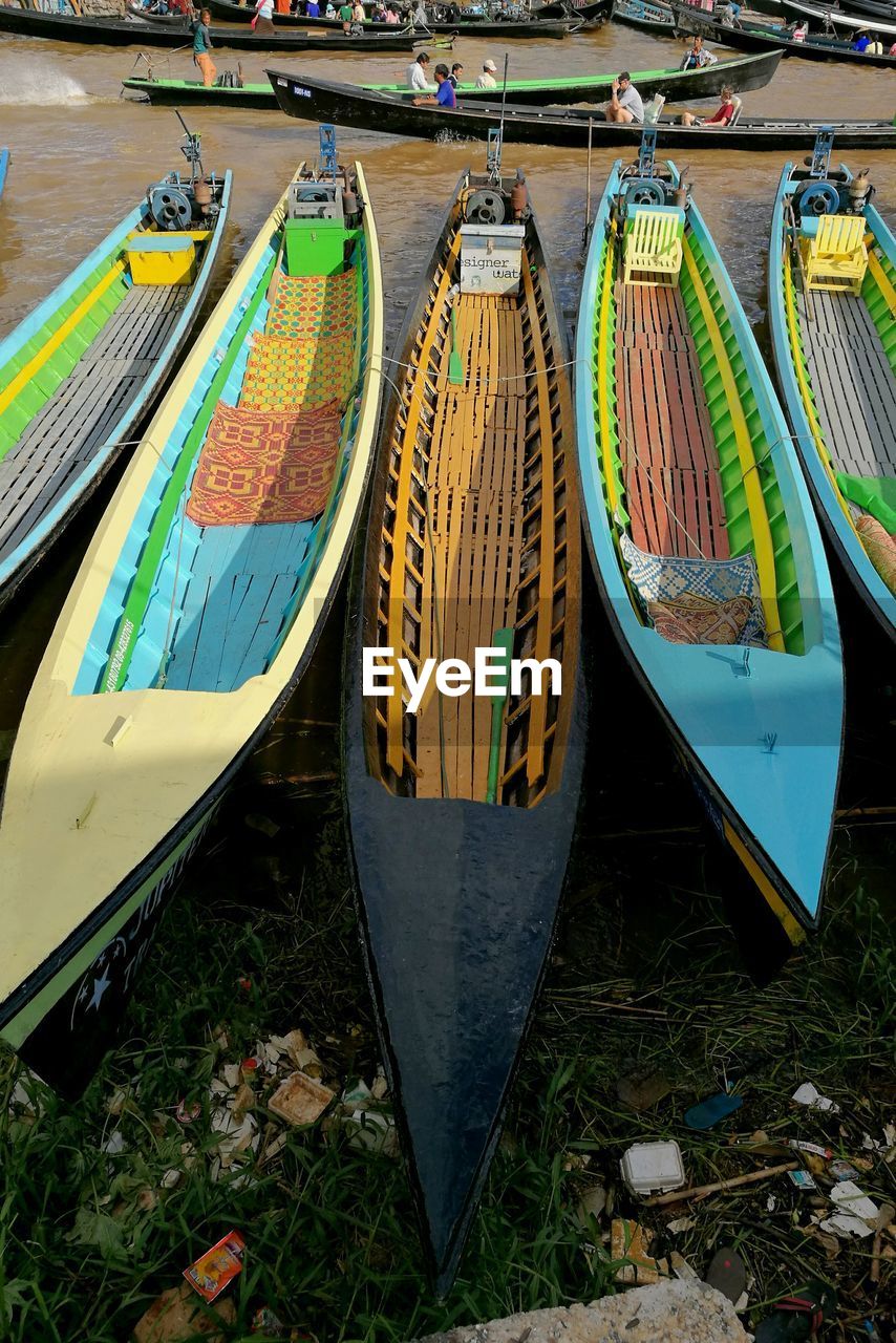 MULTI COLORED BOATS MOORED ON SHORE