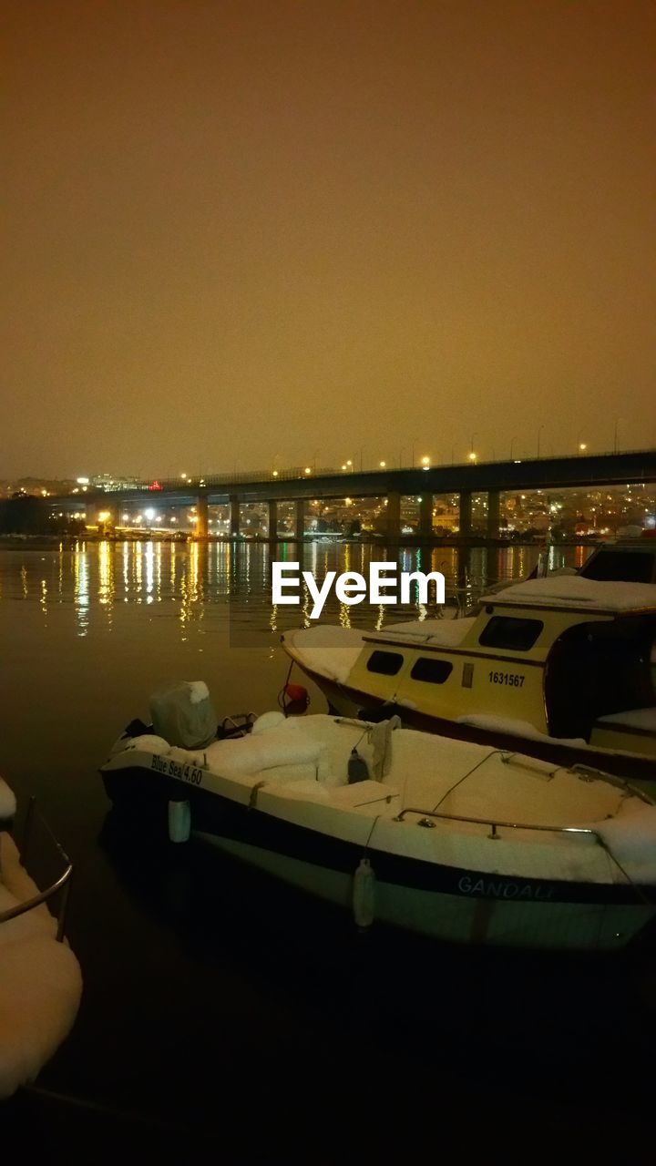 VIEW OF ILLUMINATED BOATS IN RIVER