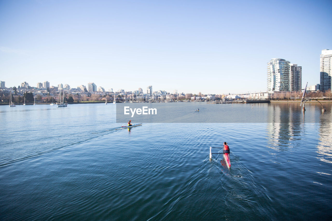 High angle view of people in canoe on river against sky