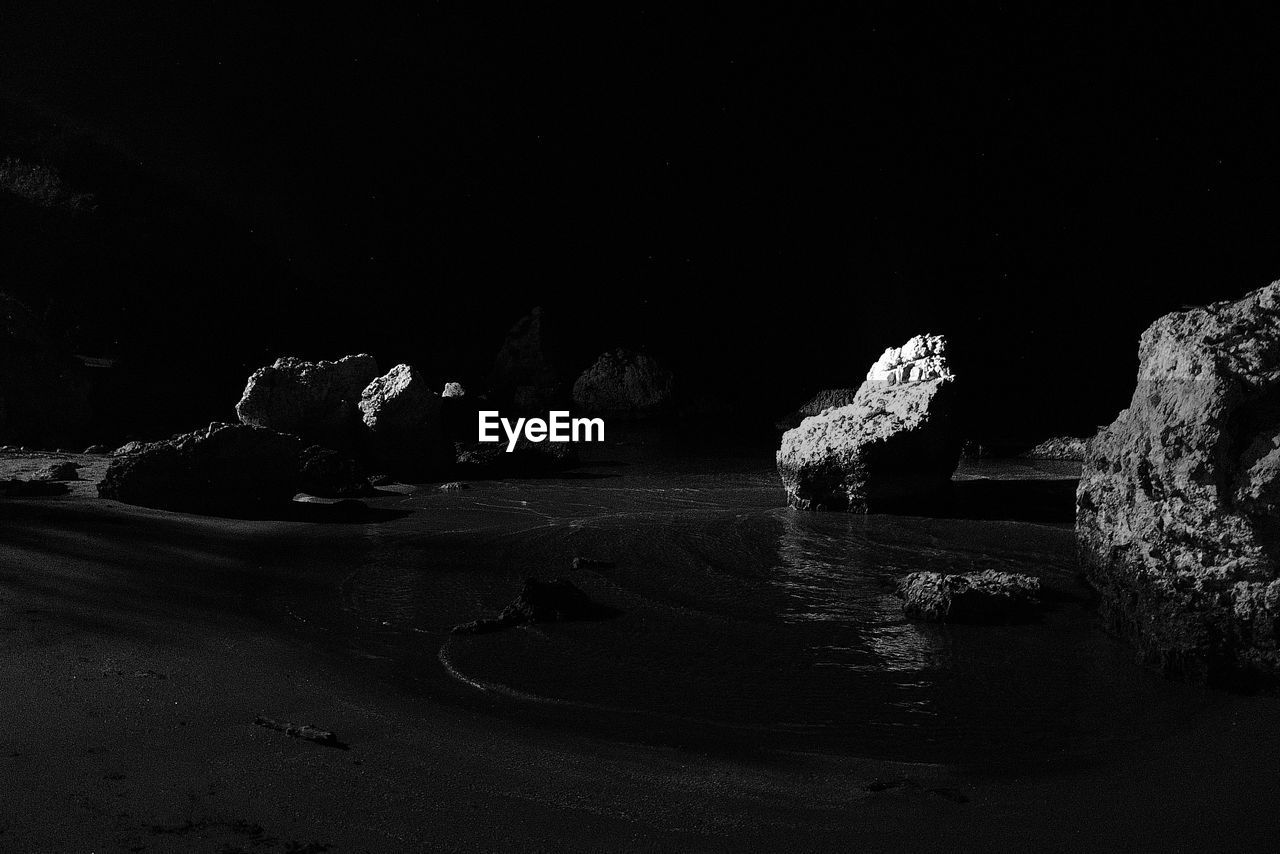 Rock formations on beach at night