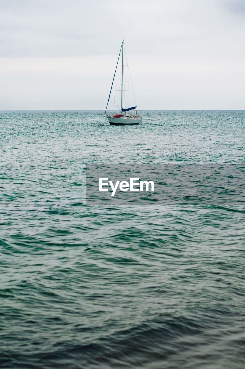 Sailboat sailing on sea against sky