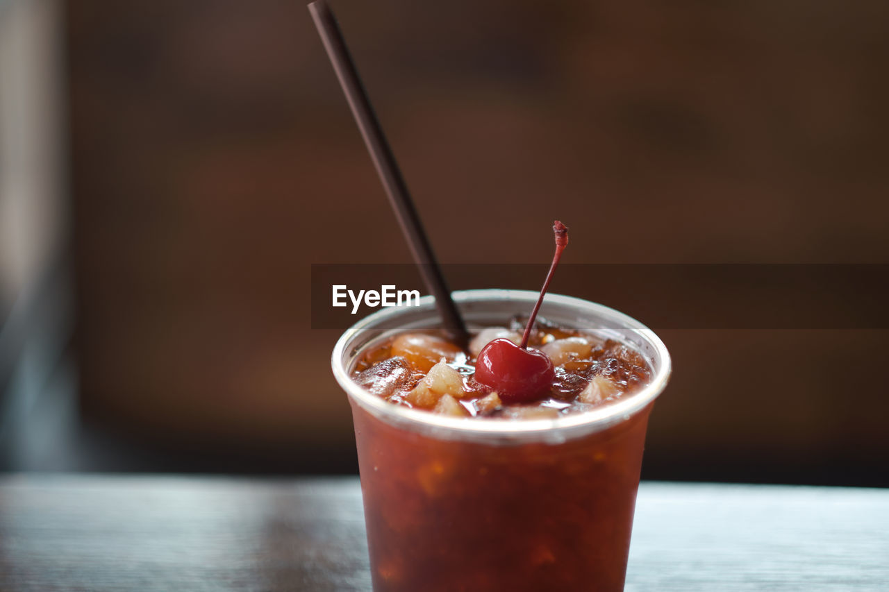 CLOSE-UP OF GLASS OF DRINK ON TABLE